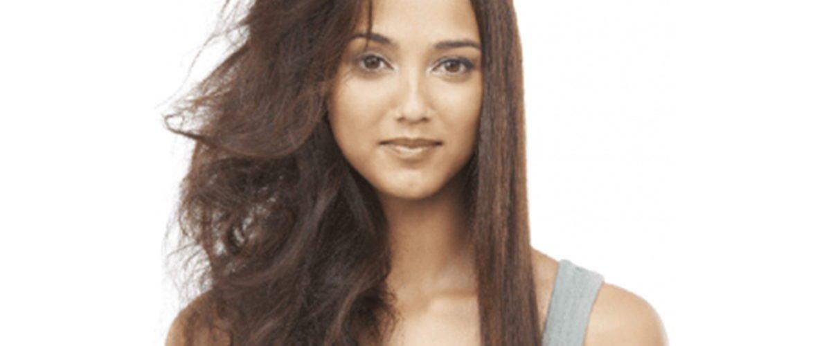 Woman with half frizzy hair and half smooth hair showing hair care results