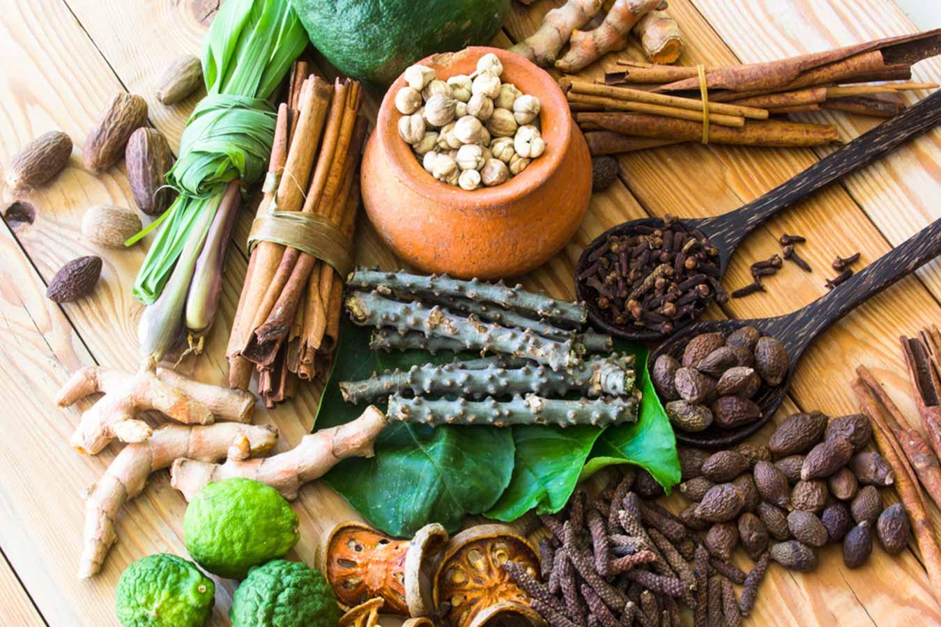 Assorted natural herbs and spices on a wooden surface for herbal skincare and wellness