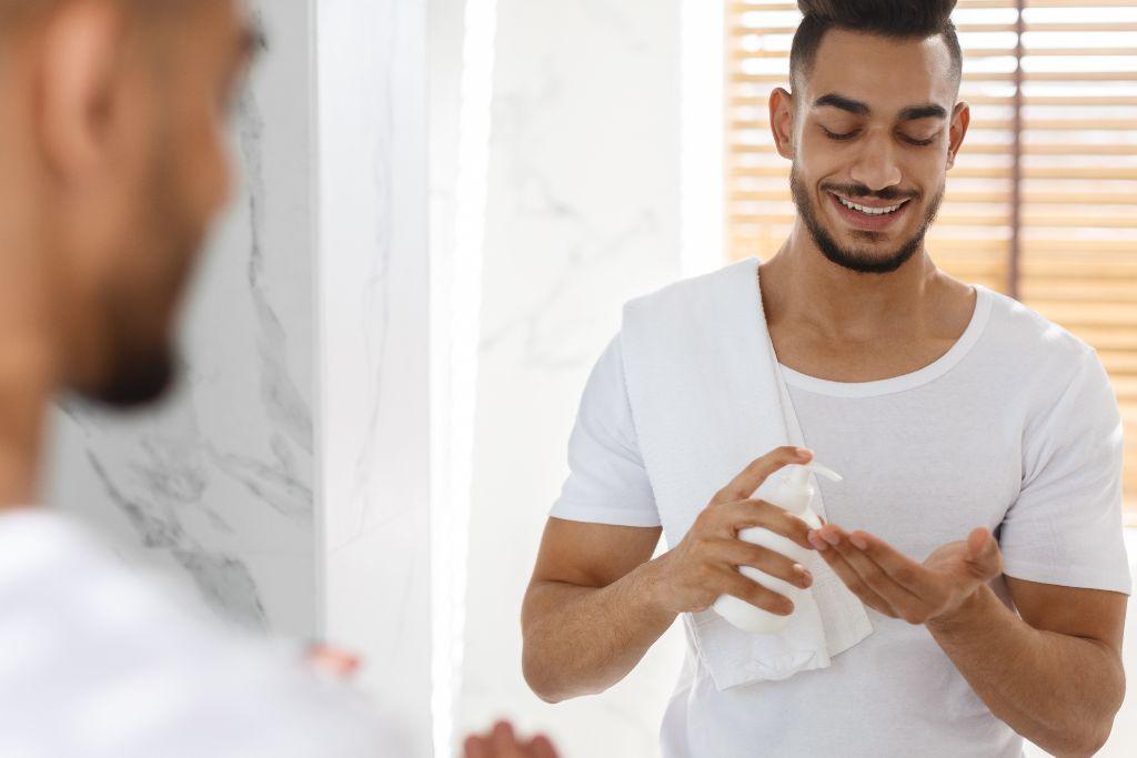 Man applying skincare product in bathroom, healthy skin routine for men