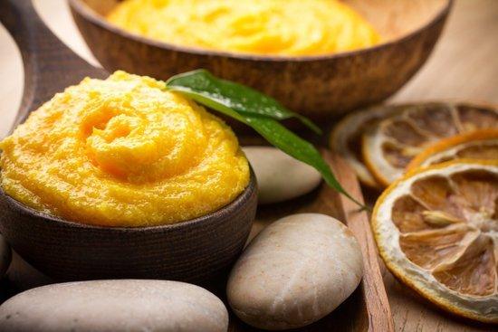 Herbal skincare face mask in wooden bowl with natural stones and dried citrus slices